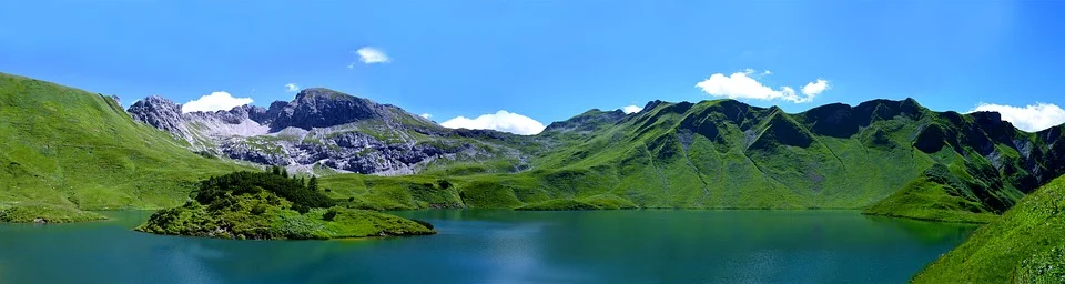 In the photograph we can see mountains and a lake with a beautiful blue sky